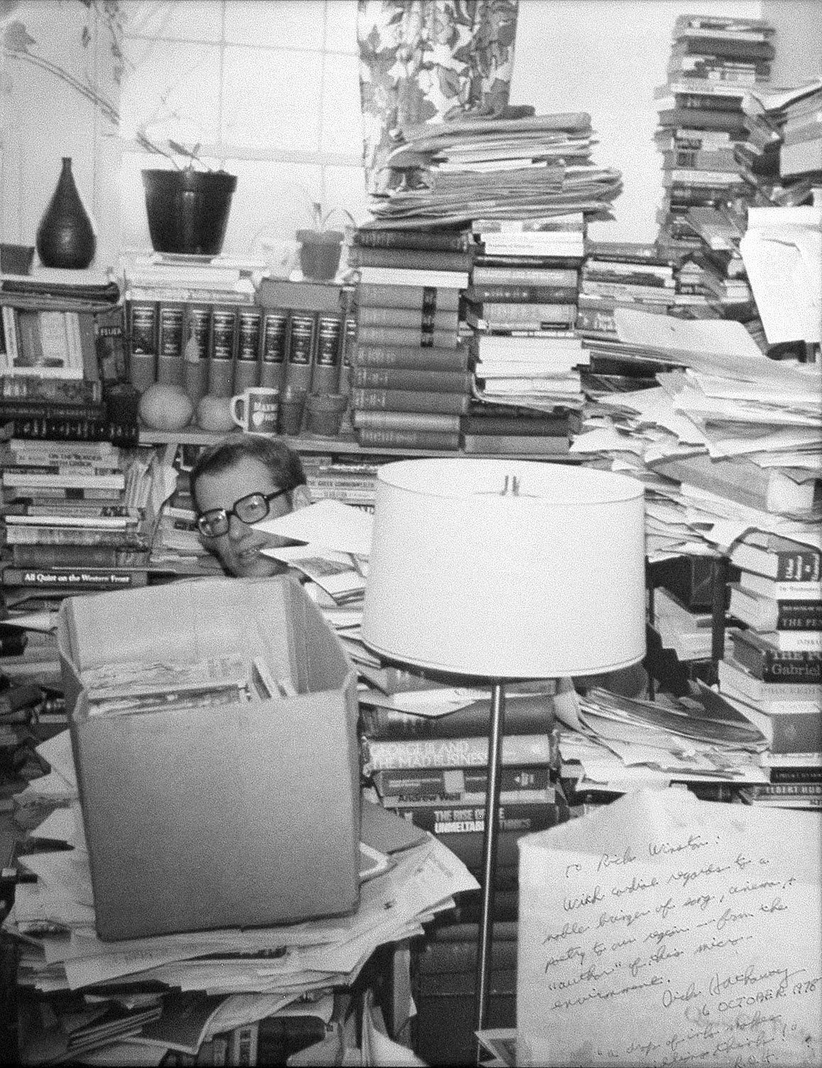 Richard Hathaway sitting at desk behind piles of paper
